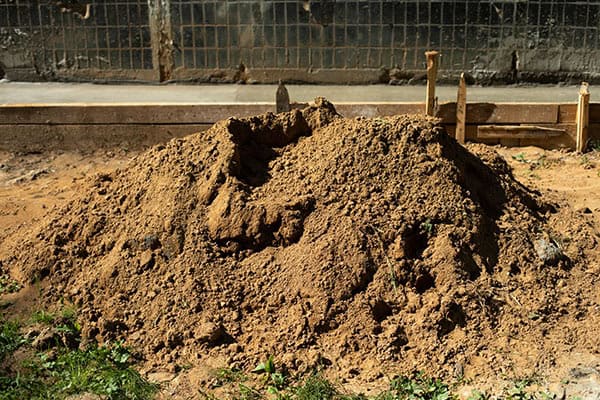 Pile of dirt and sand sitting outside a home construction site